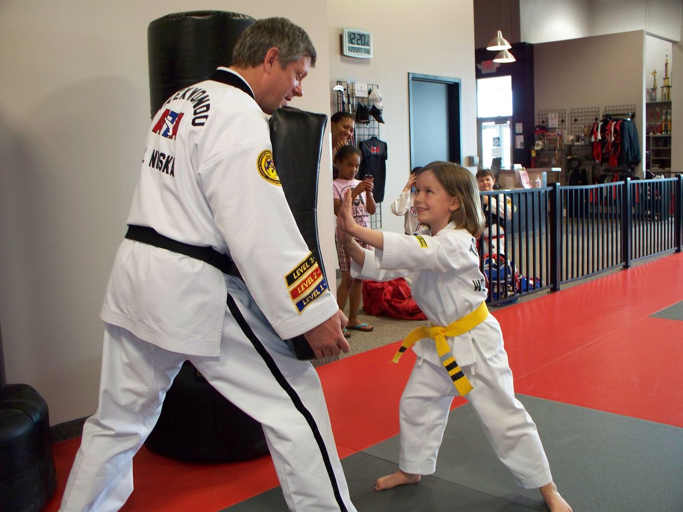 Master Dave Niska high-fiving a young Taekwondo student at Excel Martial Arts